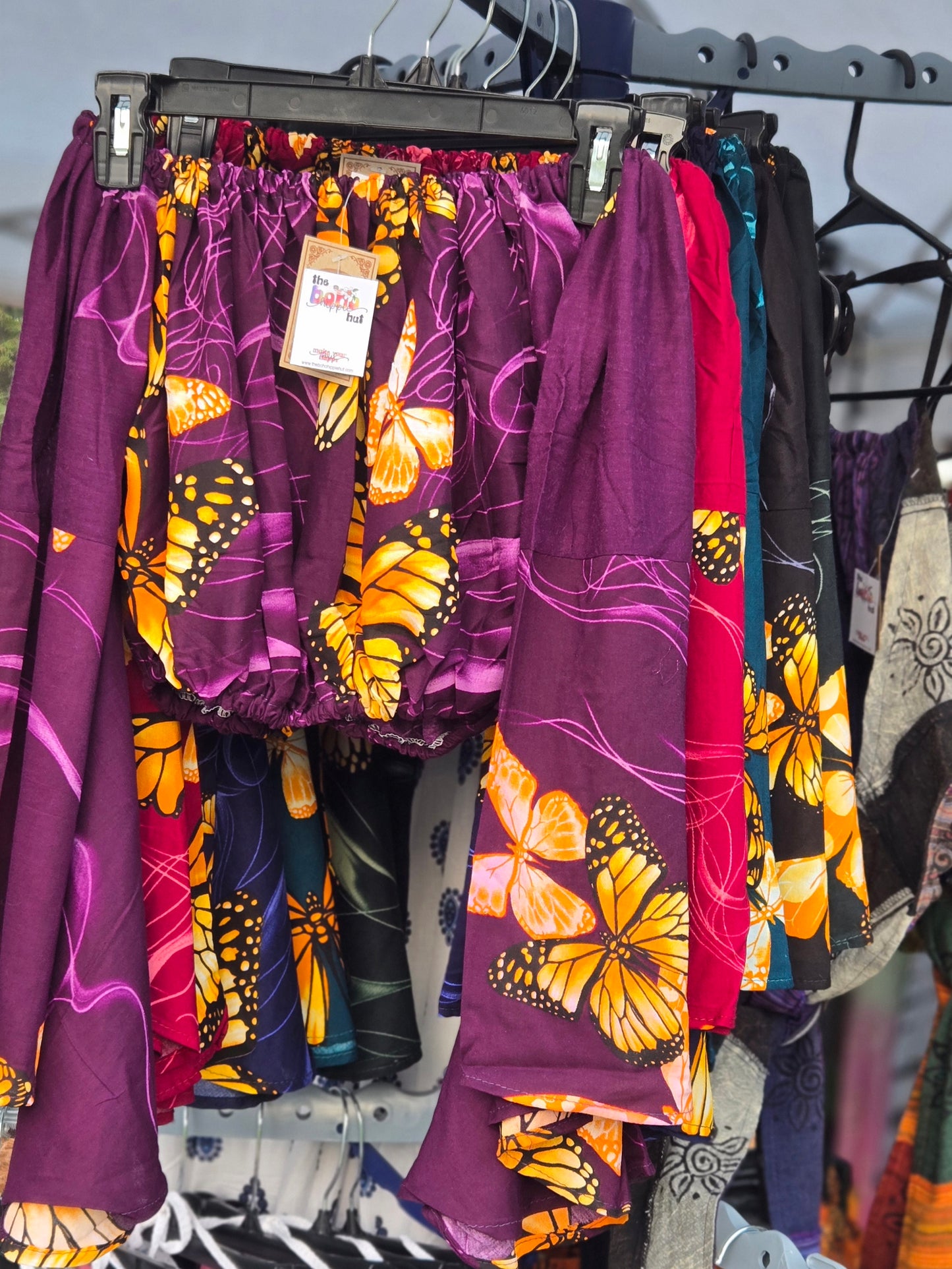 Purple crop top with butterfly design on a rack