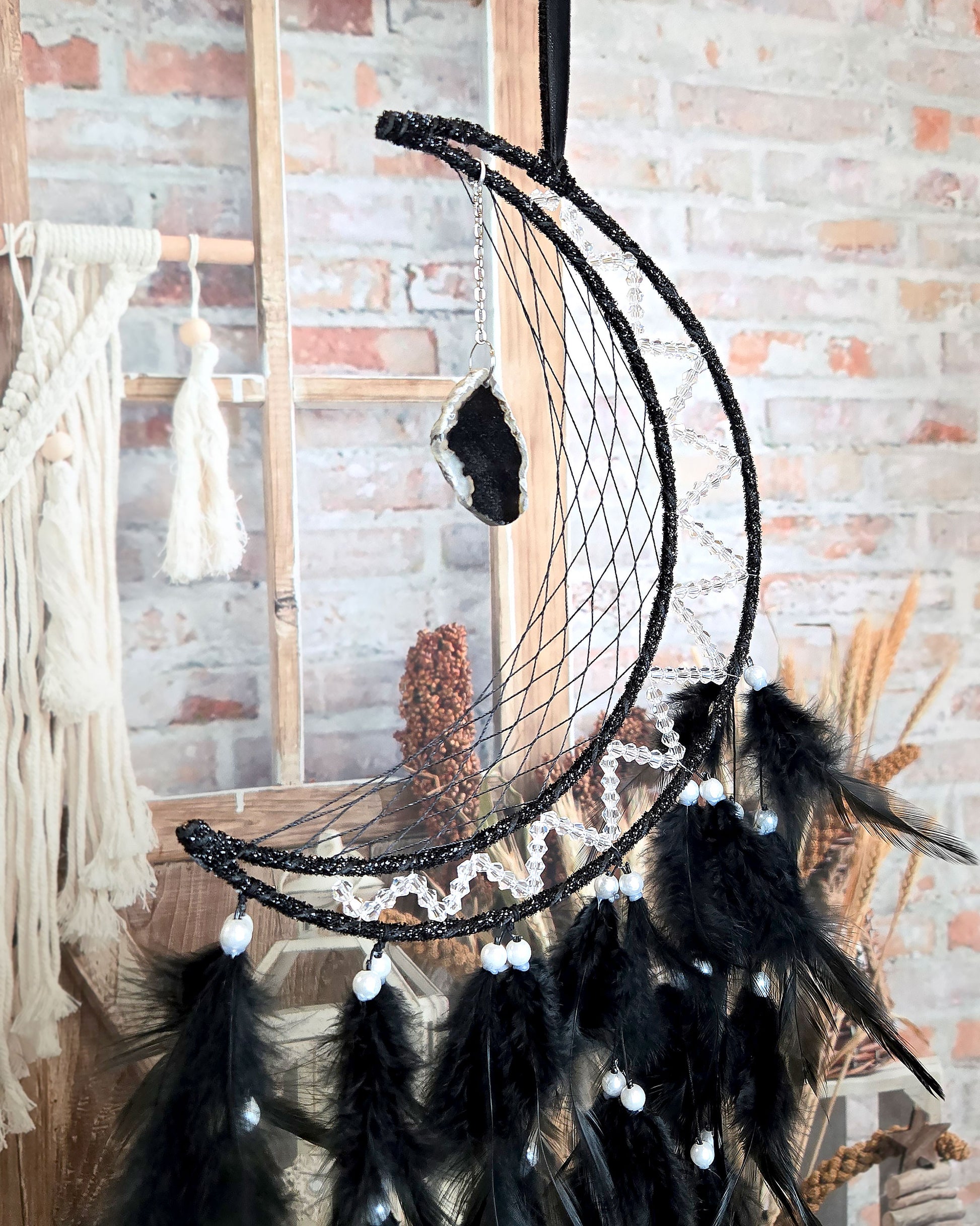 crescent moon feather dream catcher with hanging geode close up