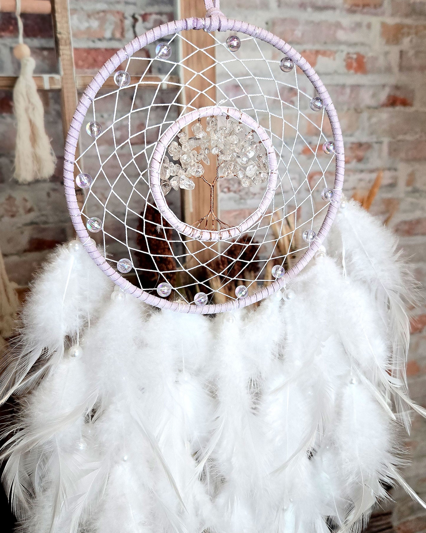 light purple and white tree of life dream catcher with feathers close up
