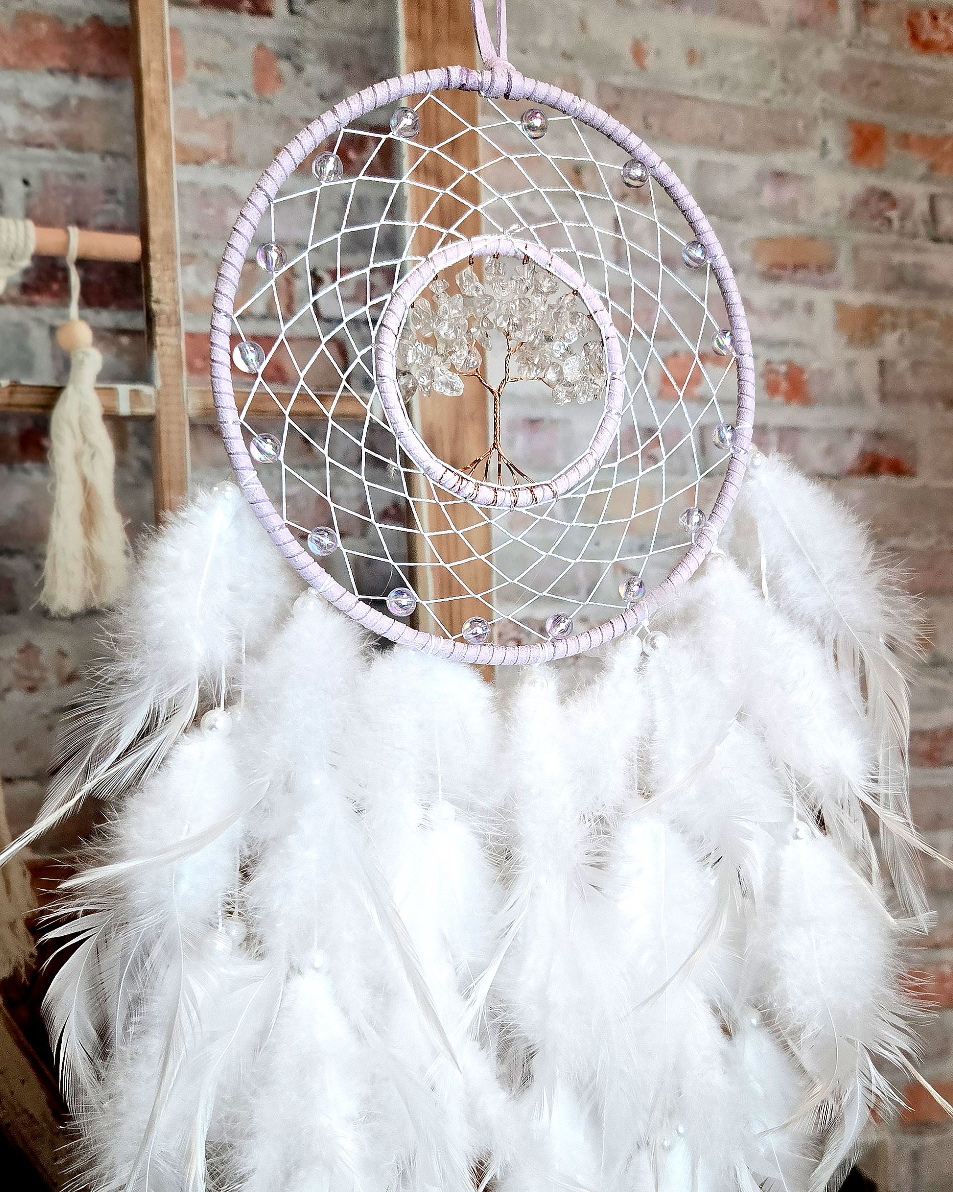 light purple and white tree of life dream catcher with feathers close up of boho room decor