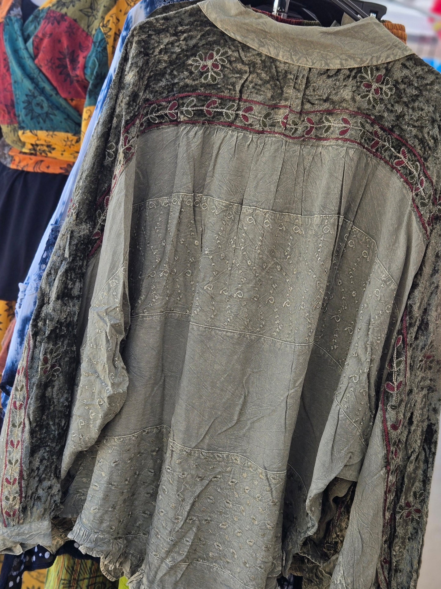 Boho style blouse with intricate patterns on a hanger