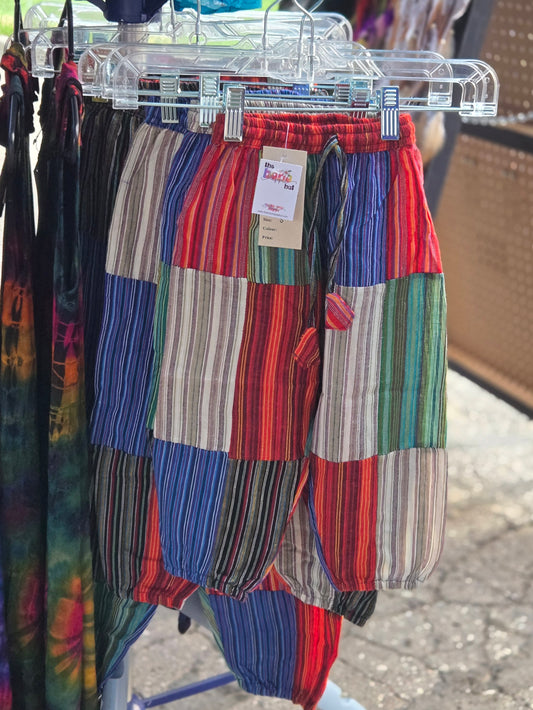 Colorful kids patchwork pants on a hanger with a blurred background