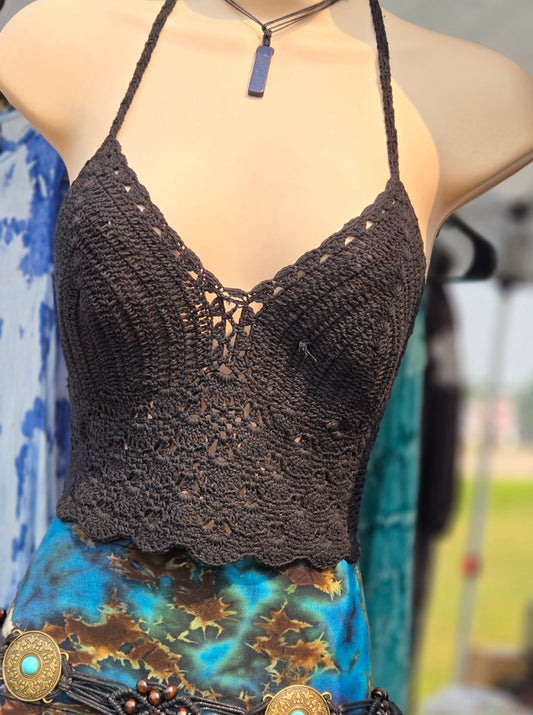Black crochet halter top on a mannequin with a colorful skirt 