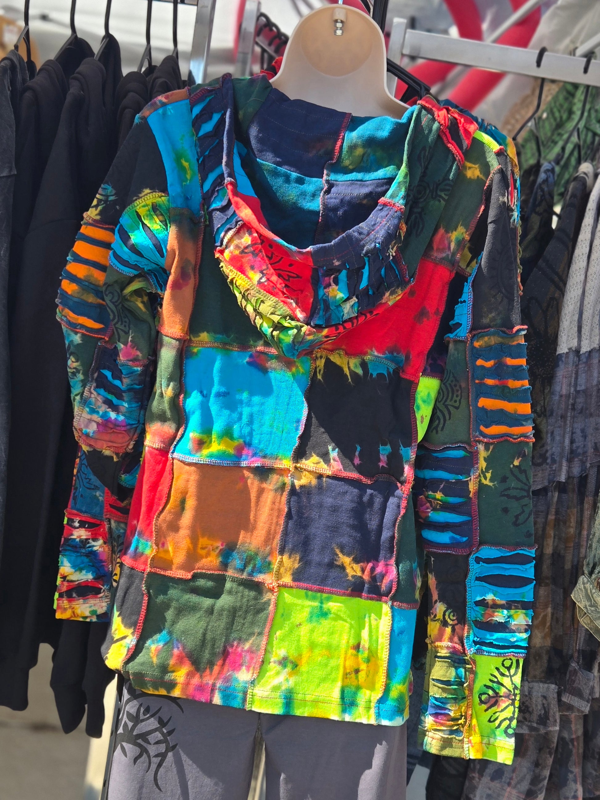 Colorful tie-dye jacket on a mannequin against a clothing store background