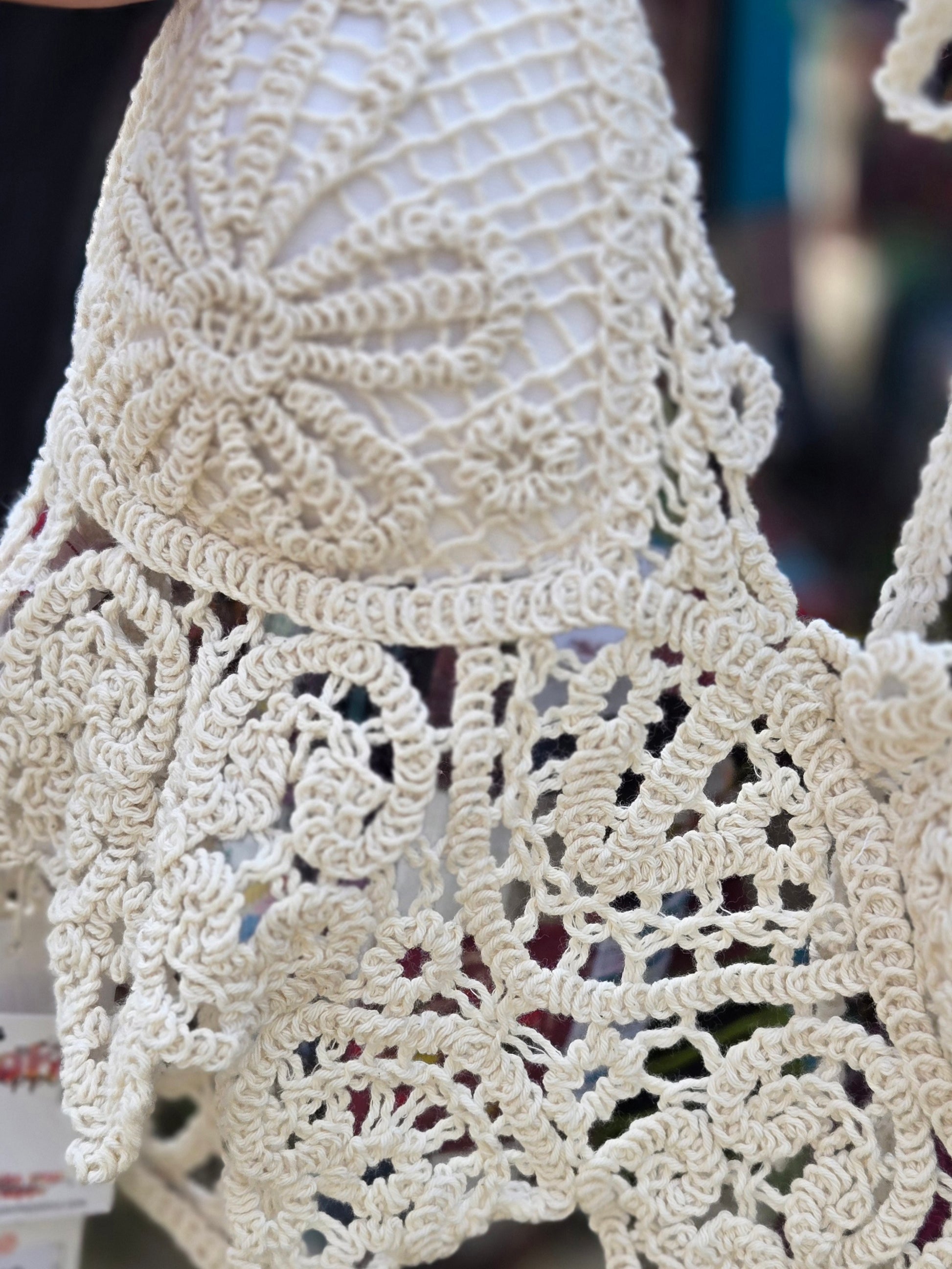 Close-up of a beige crochet halter top with intricate patterns.