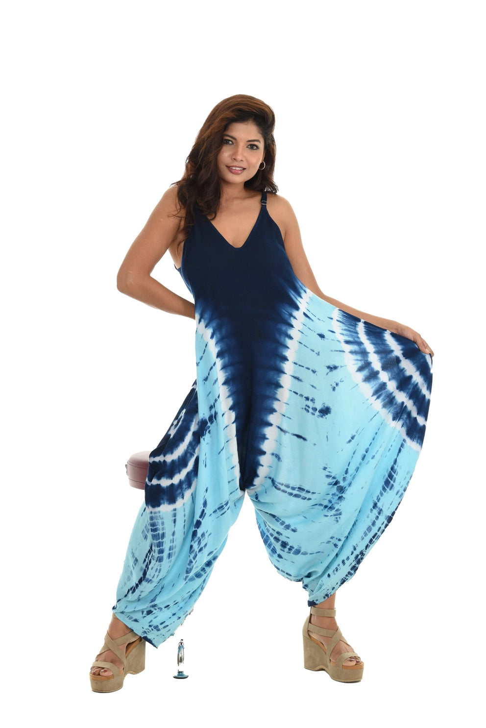 Woman wearing a blue and white tie-dye jumpsuit on a white background
