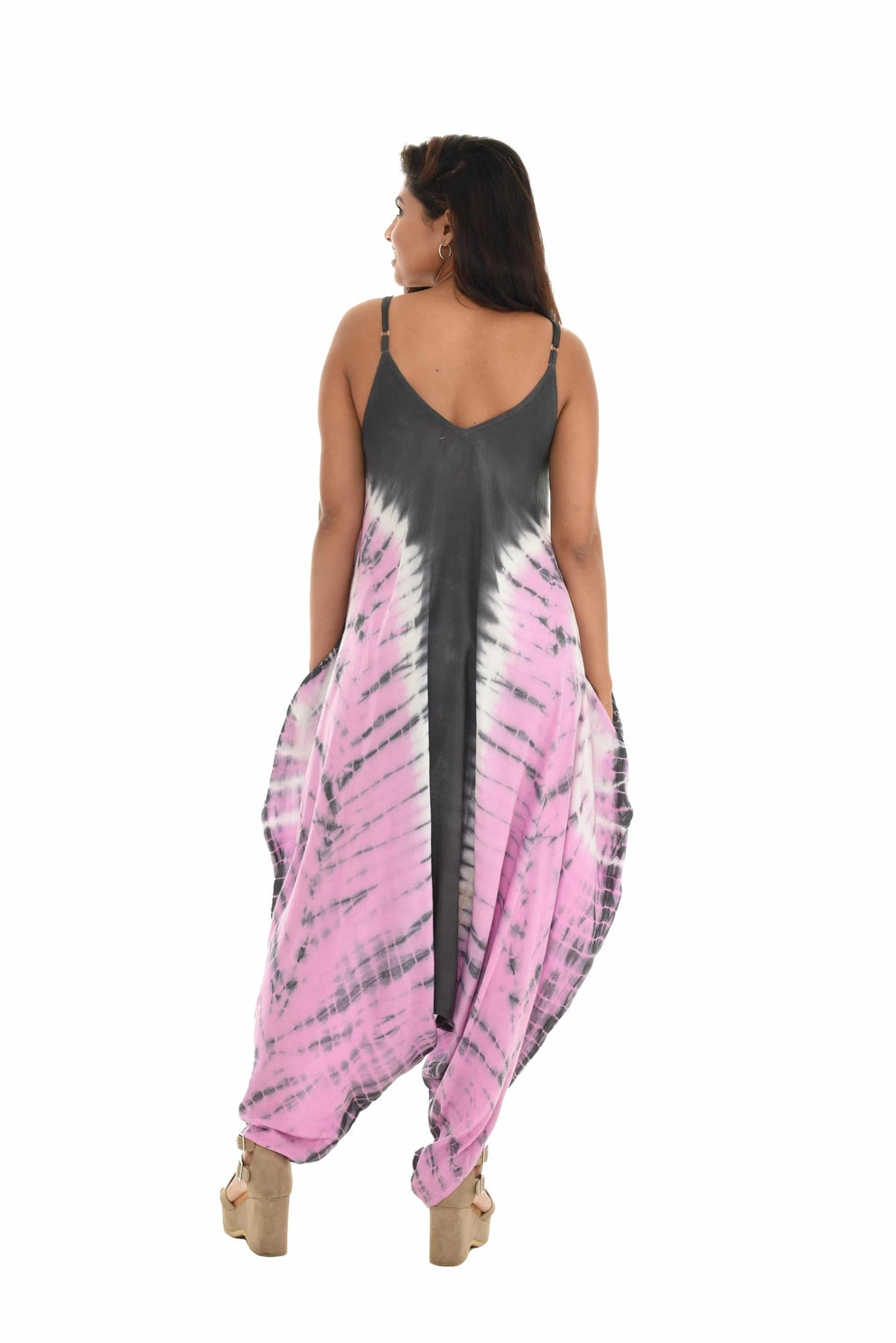 Woman wearing a pink and gray tie-dye jumpsuit on a white background