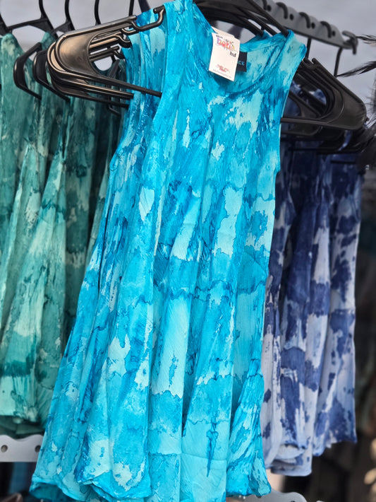 Blue girls tie dye dress on a hanger with other dresses in the background
