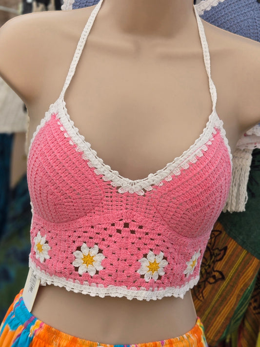 Pink crochet halter top with white daisy patterns on a mannequin