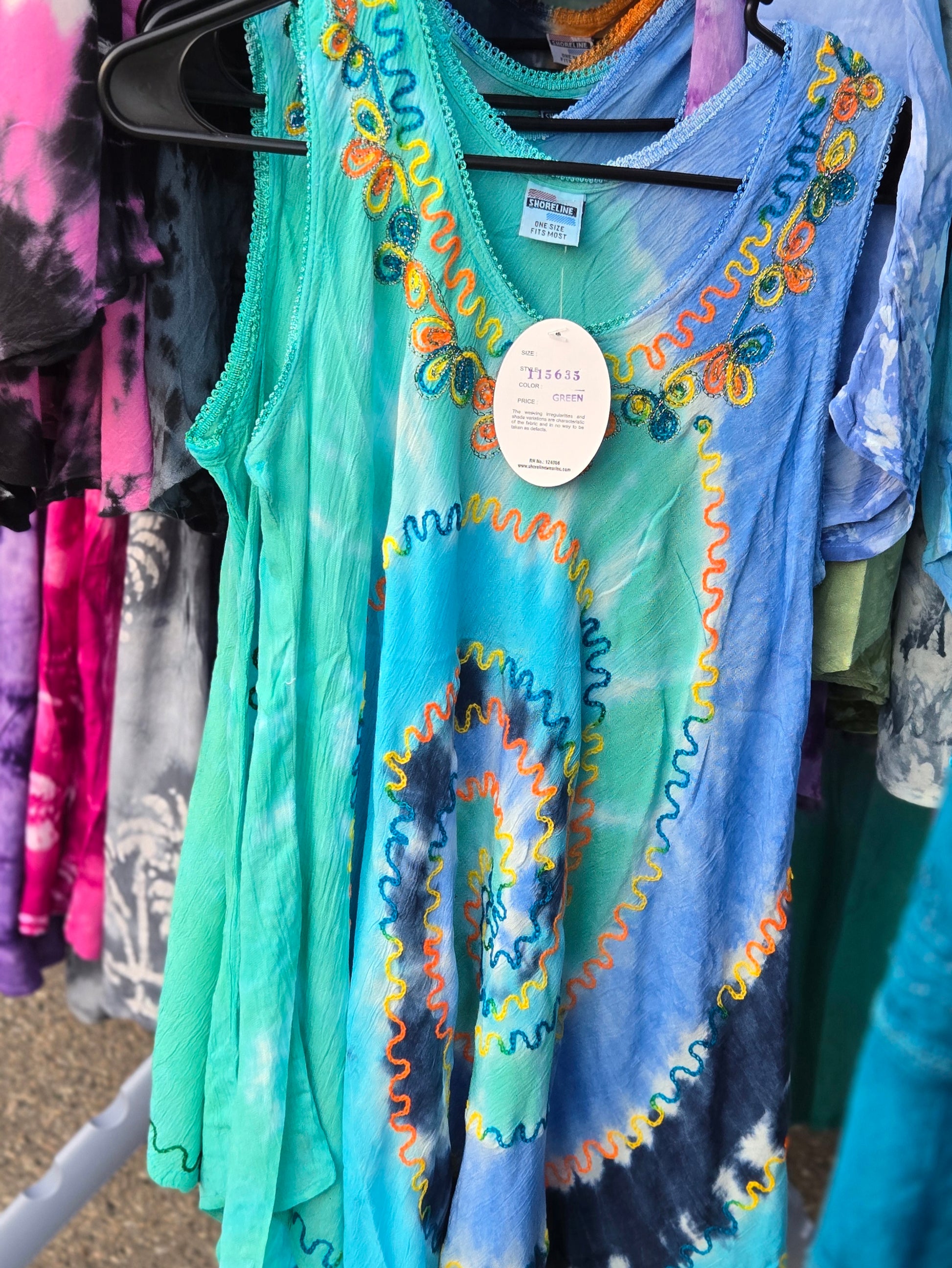 Colorful sleeveless tank top with tie-dye pattern on a rack