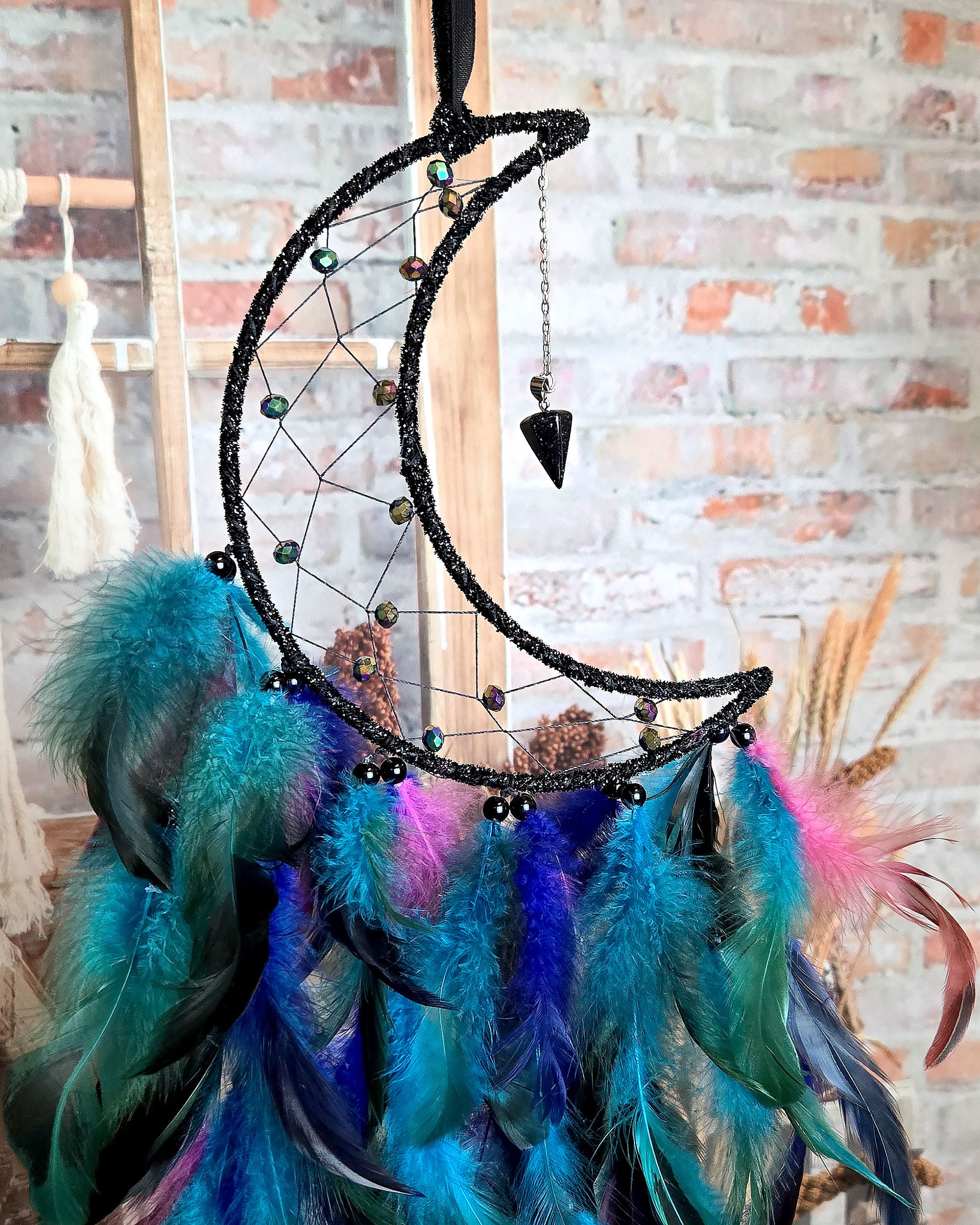 black and blue crescent moon dream catcher with feathers close up