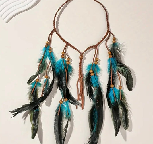 A hippie style headband with black and blue feathers attached to it, displayed against a neutral background.