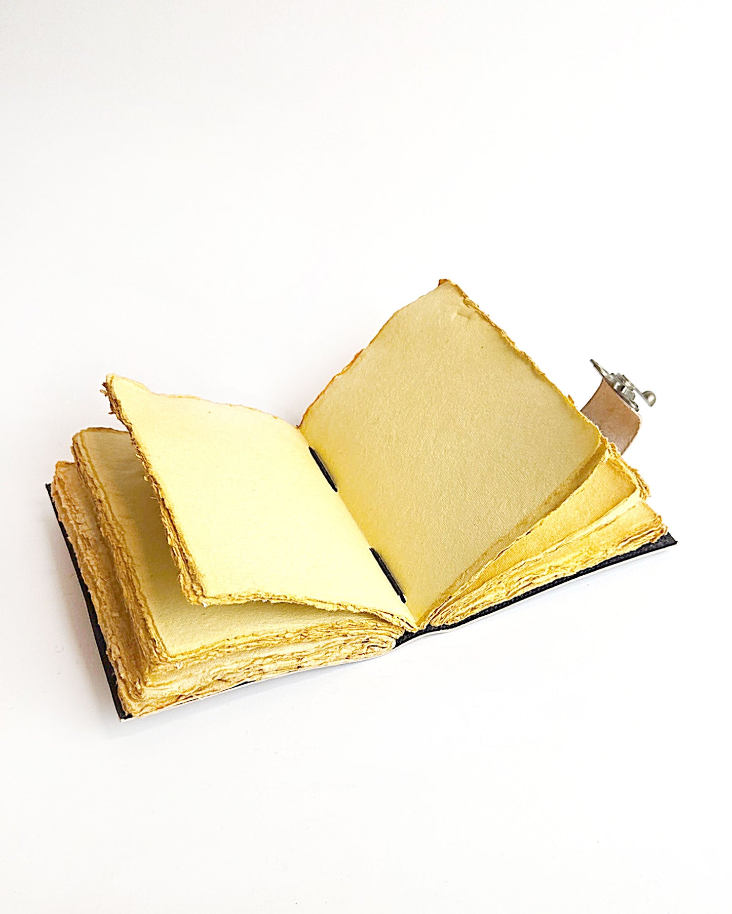 inside of leather journal with compass design antique buckle closure and deckle edge vintage look paper 