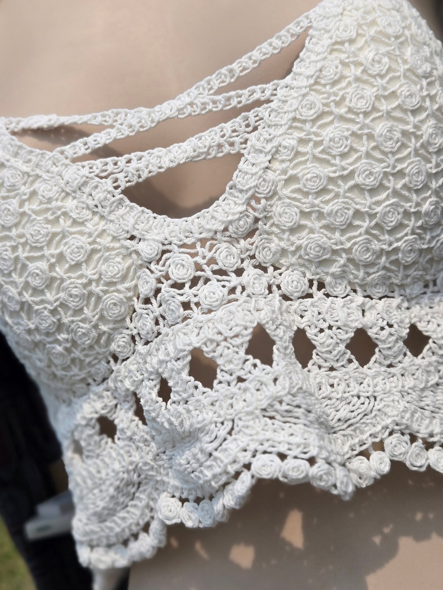 Close-up of a white crochet halter top on a mannequin