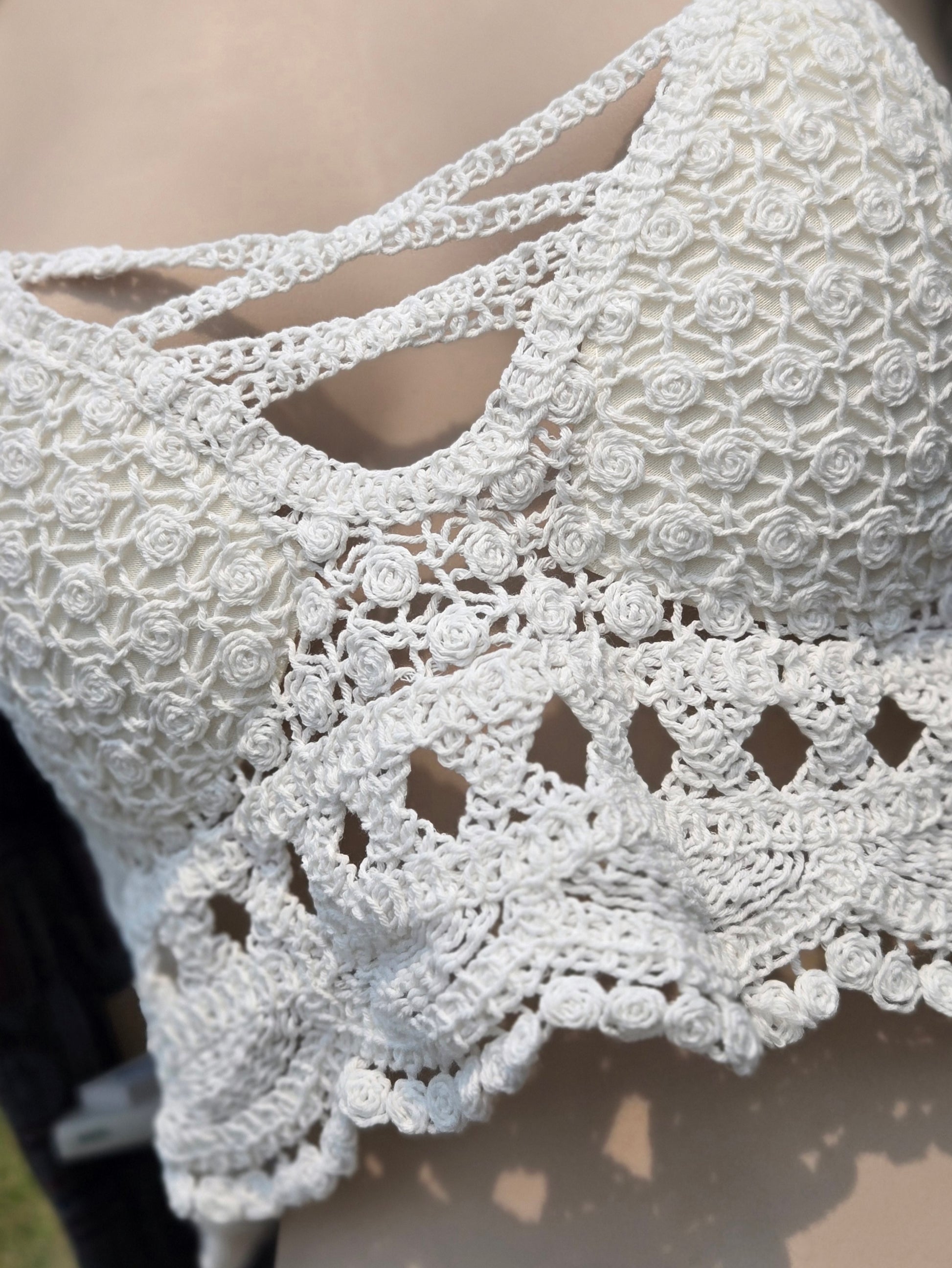 Close-up of a white crochet halter top on a mannequin