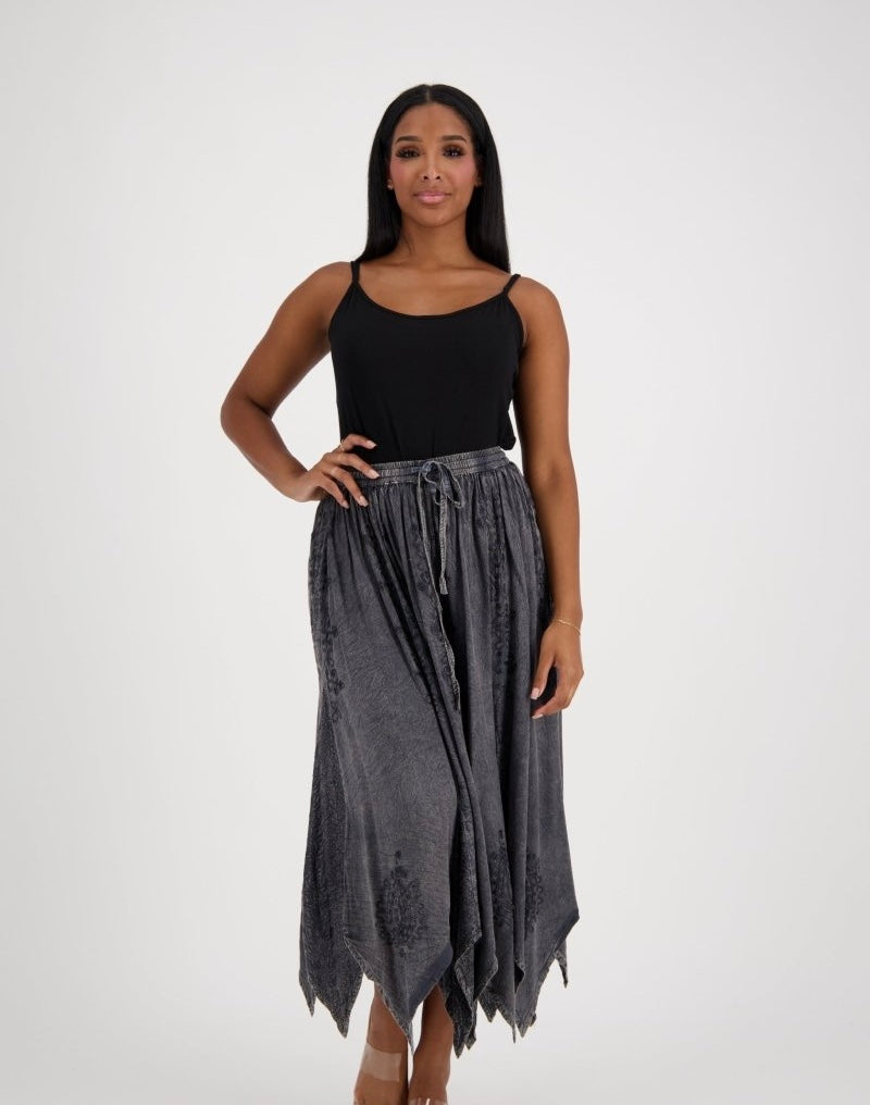 Woman wearing a black top and gray skirt on a white background