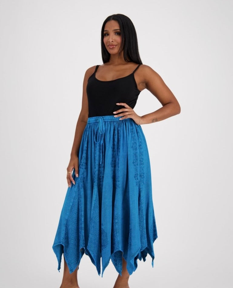 Woman wearing a turquoise skirt and black top on a white background