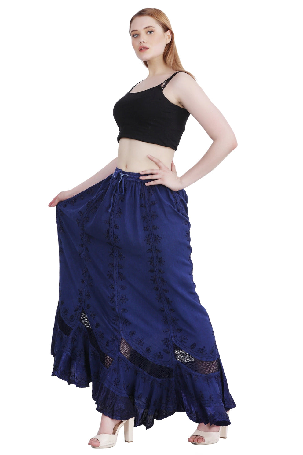 Woman wearing a black top and navy long boho skirt on a white background