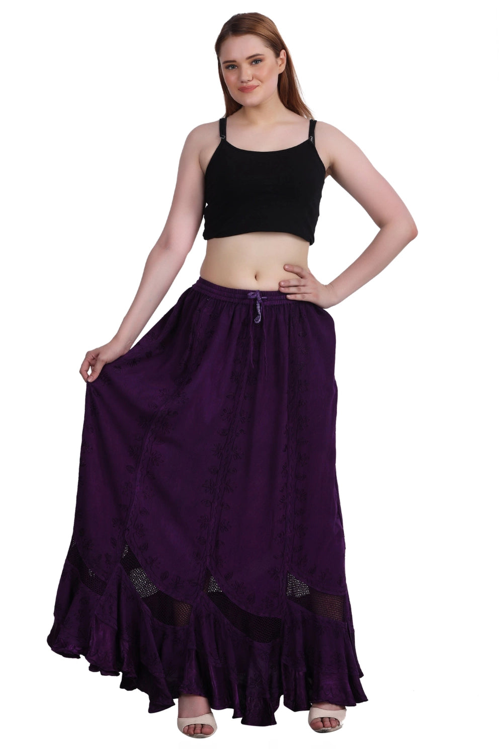 Woman wearing a black top and long purple boho skirt on a white background