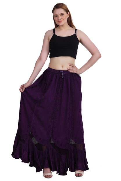 Woman wearing a black top and long purple boho skirt on a white background