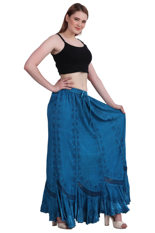 Woman wearing a turquoise long boho skirt and black top on a white background