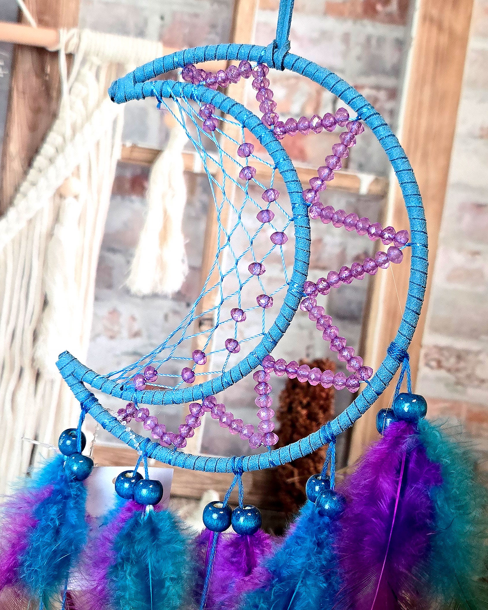 close up of blue and purple crescent moon feather dream catcher 