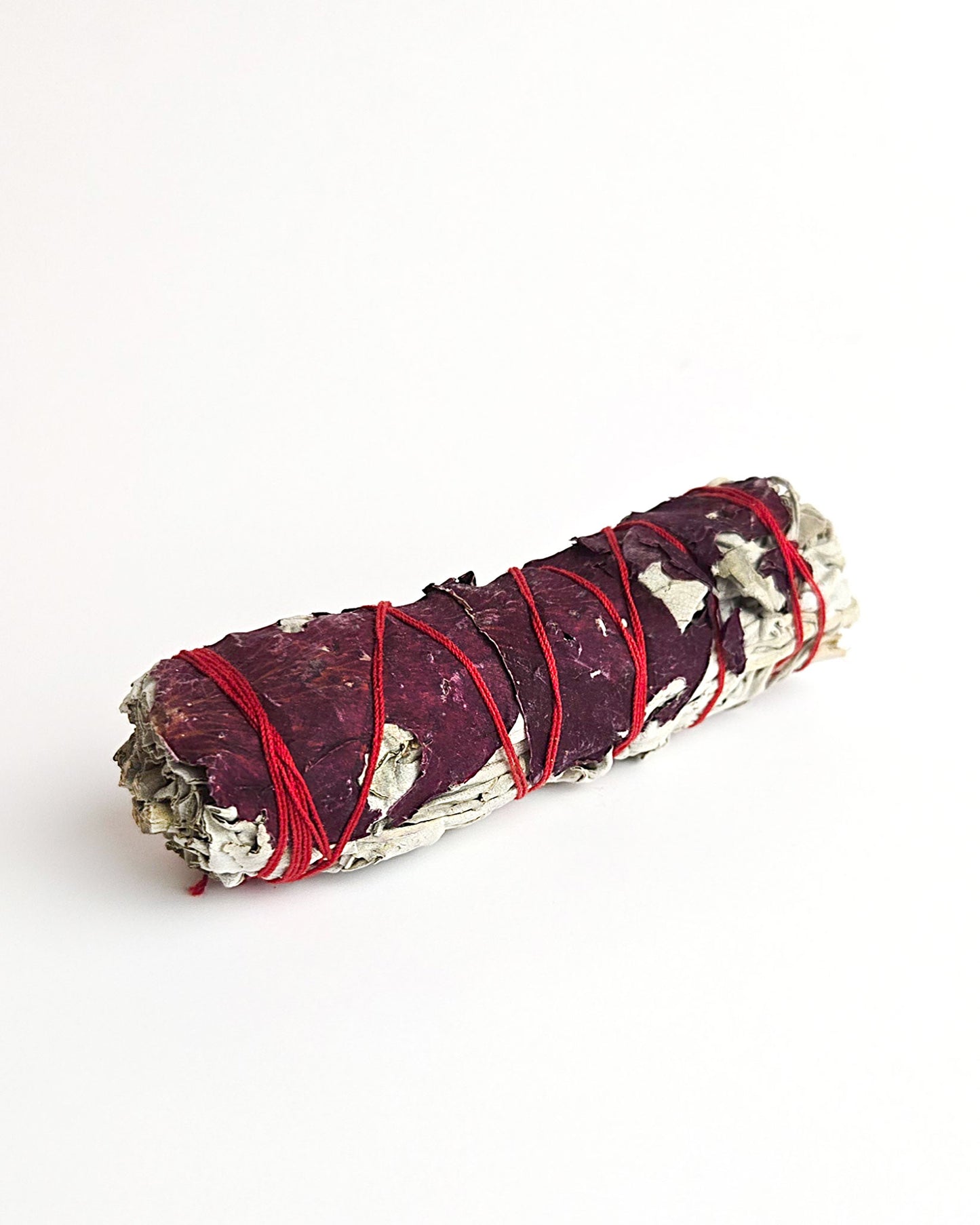 sage smudge stick with red rose petals