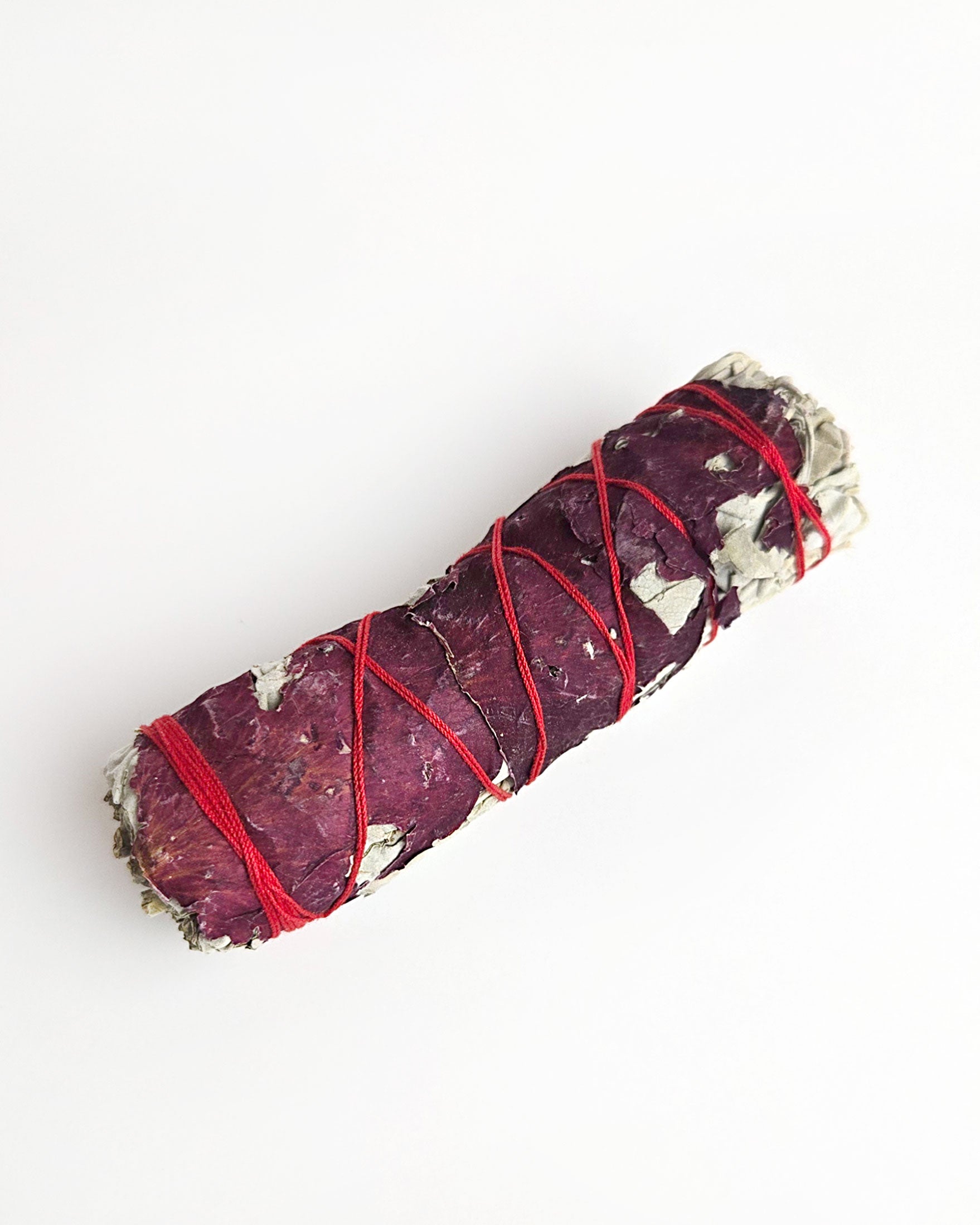 sage smudge stick with red rose petals