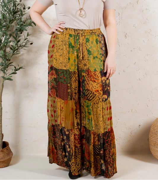 Person wearing a colorful patchwork skirt with a neutral background