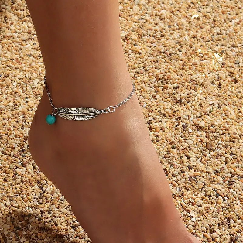 silver color feather anklet with turquoise bead on ankle